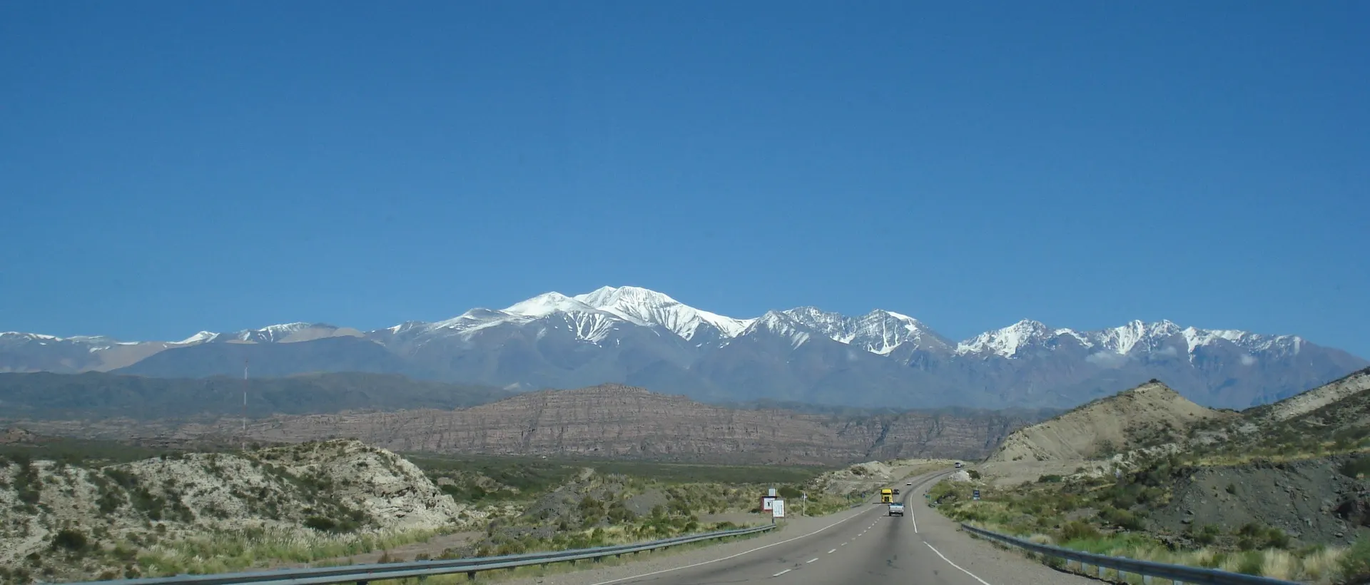 Ruta recta en Mendoza que avanza hacia la cordillera de los Andes nevada